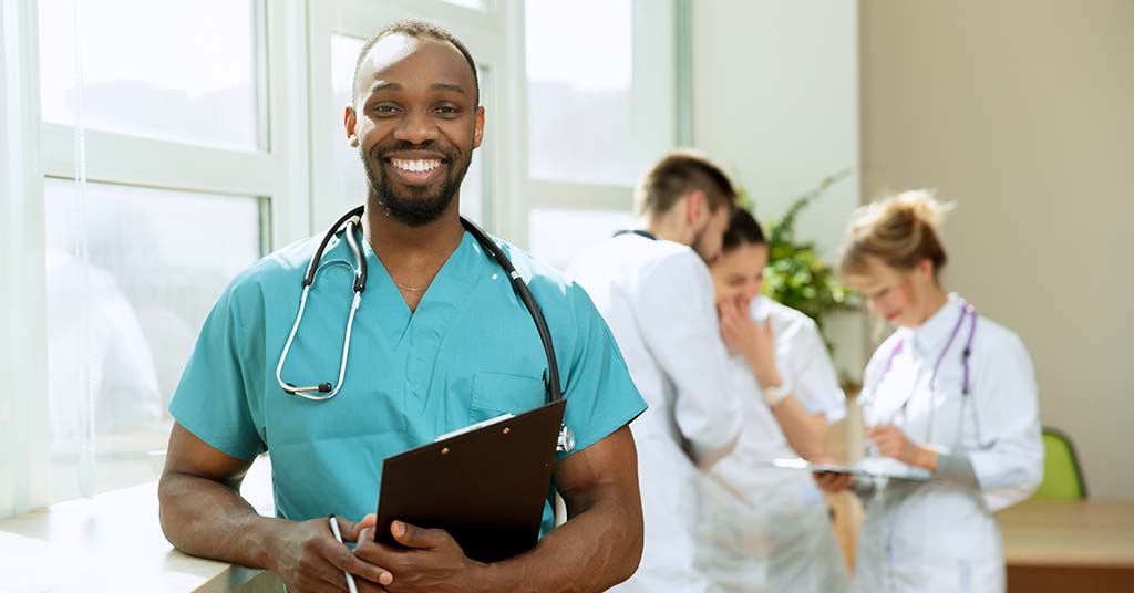 Smiling African doctor in scrubs